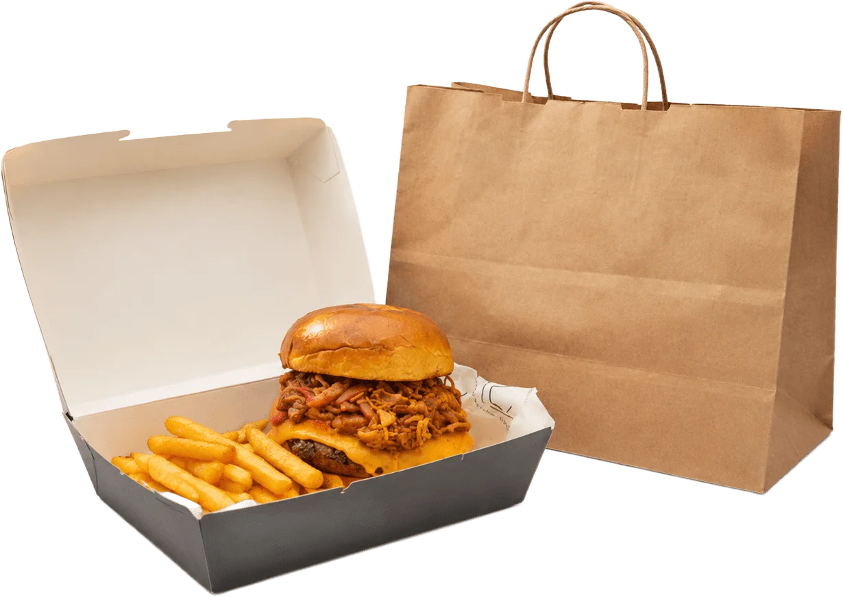 Hamburguesa de La Loli con patatas en su caja, lista para llevar, junto a la bolsa de papel